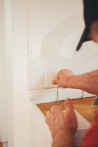 Man installing kitchen backsplash