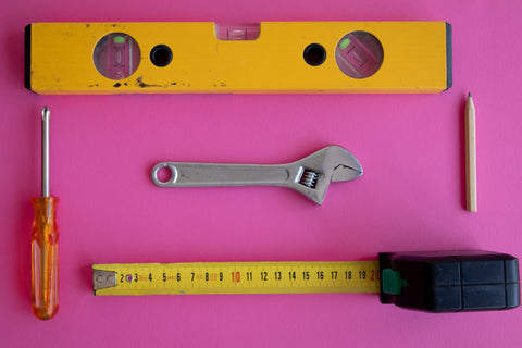 Assorted tools on a pink background